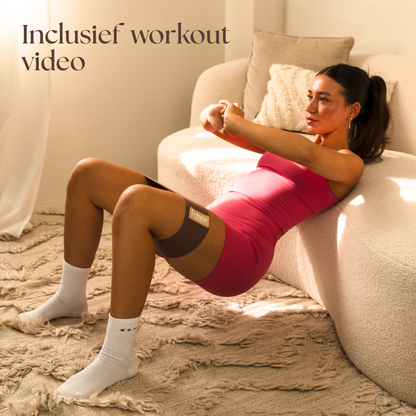 Vrouw doet een workout: hip thrust met de weerstandsband, voor extra uitdaging en grotere billen.